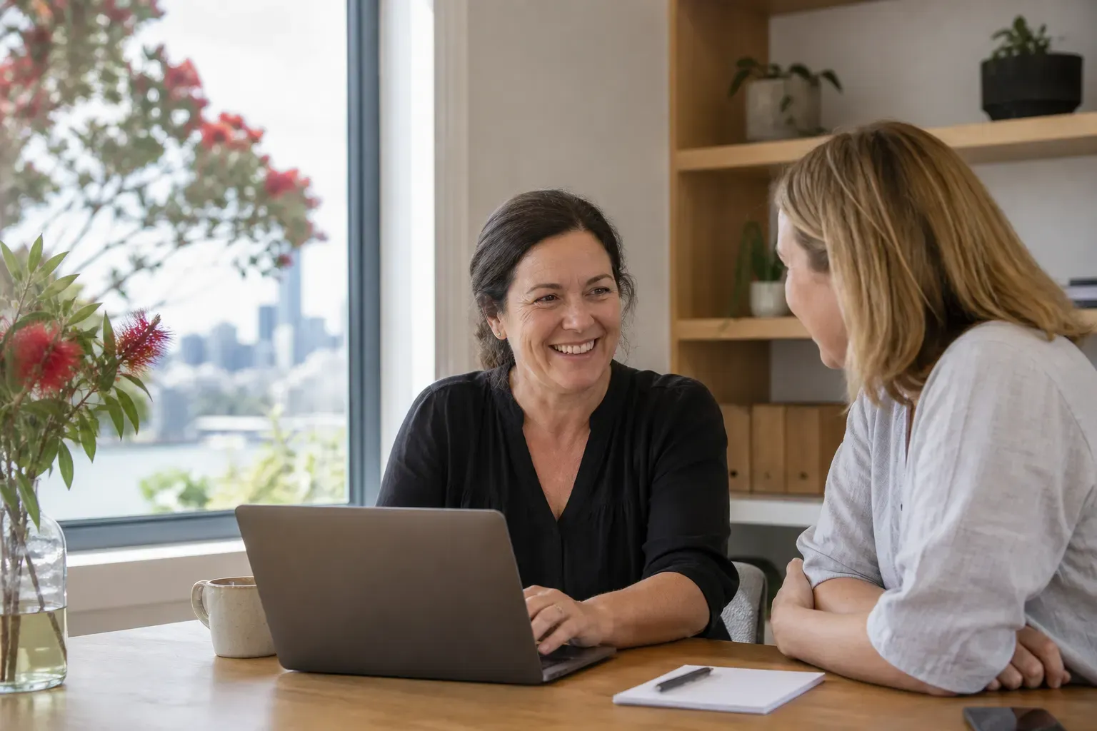 Two colleagues working through a task together in a bright Auckland workspace